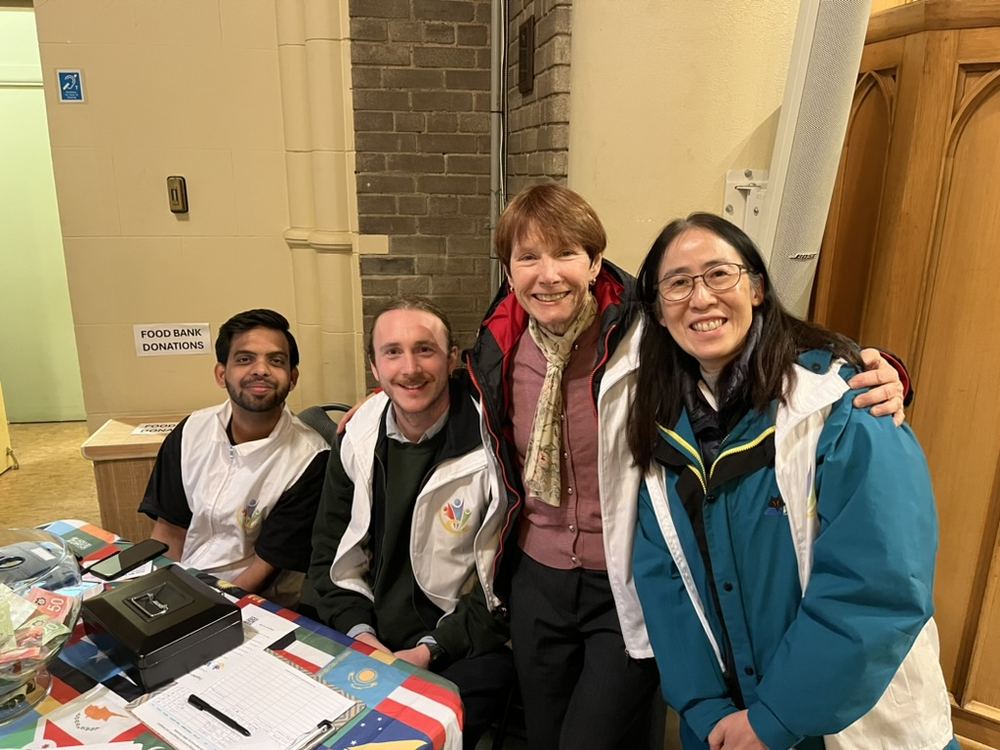 Four VICCIR Health and Cultural Ambassadors smiling together at a community event table